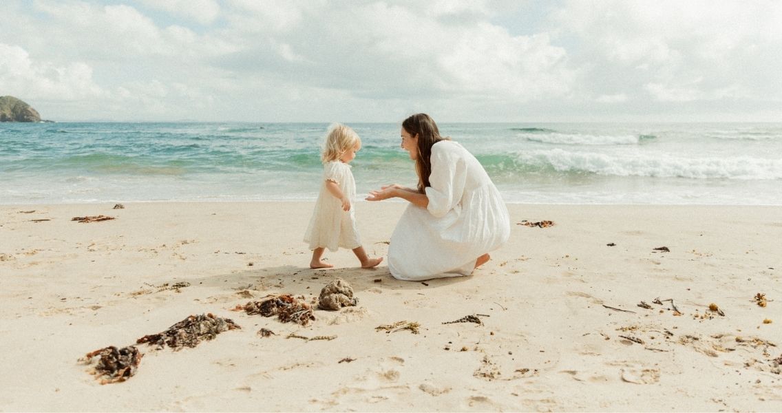 Em with her toddler on the beach